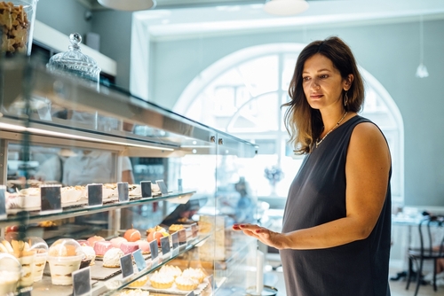 Gestante que recebeu atendimento preferencial olhando alimentos em refrigerador