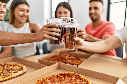 pessoas apreciando combos de pizza e guaraná Antarctica