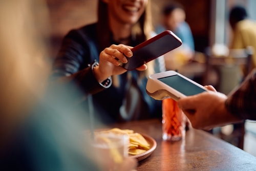 Mulher pagando conta em bar sem consumo mínimo