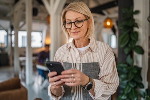 Empreendedora concentrada fazendo o fechamento de ano pelo celular