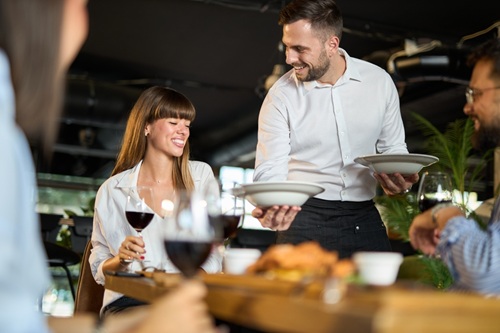 Garçom de restaurante tendo um bom relacionamento com os clientes