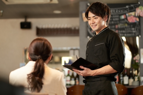 Garçom usando gatilhos mentais com cliente de restaurante