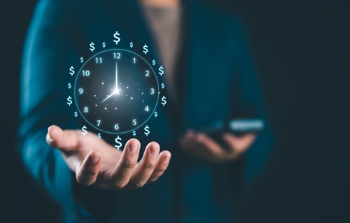 Homem segurando relógio com cifrão no lugar dos números - horários de atendimento